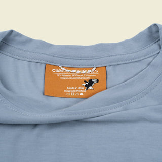 Curious Creatures custom woven label on the inside neck showing, made in the USA, designed in Montana.