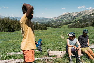 Chima stands atop the top of red cub trail and canyon after a solid mountain bike climb and enjoys some water with friends Hannah and Pasha