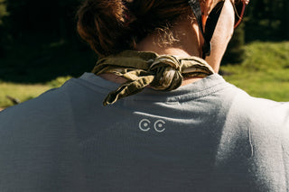 Close up of Hannah’s back where the natural texture of the tank visible and the curious creatures creatures eyes logo is front and center