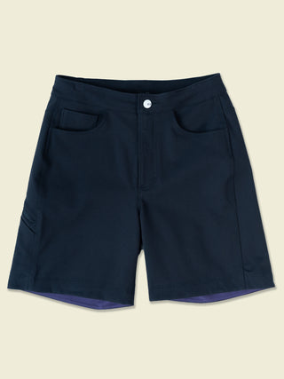 A bright white button with black eyes logo pops on a laydown of classic black shorts with hand pockets built tough