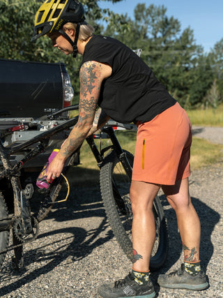 Holly loading up her bike before going out for a ride wearing a black tank and pink shorts