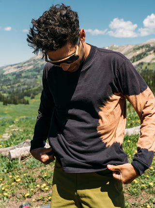 Pasha adjusts his black longsleeve tie dye shirt somewhere in the Gallatin Mountains Montana