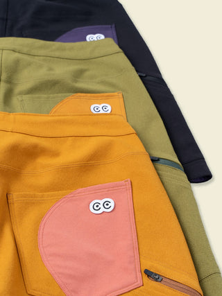 White eye logo woven patch labels pop out on a multi color display of the various Ramble Scramble shorts rear pockets