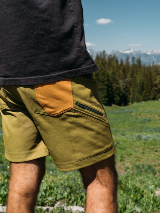 Pasha looks out over a classic Montana vista wearing his green avacado ramble scramble shorts