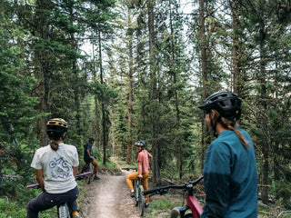 Group of bike friends taking a break on Mountains to Meadow in Big Sky wearing the bikeface tee