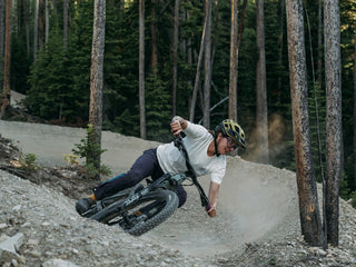 Rachel Long shreds through a huge berm on Mountain to Meadow in Bigsky wearing a white Tee and purple pants