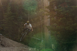 Rachel Long hits a kicker on MTM trail in moody forested light