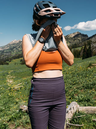 Hannah wiping sweat from her face with the Taylor Hilgard mountains behind her wearing high waist Marilyn Shorts
